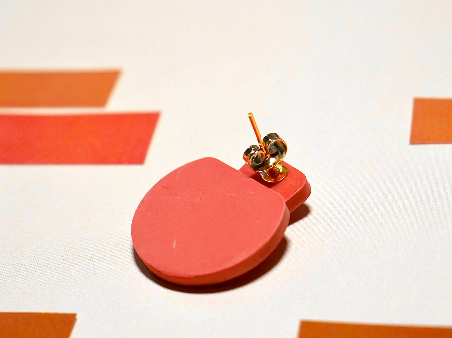 face arrière d'une boucle d'oreille en argile polymère couleur terracotta et son attache en acier inoxydable doré