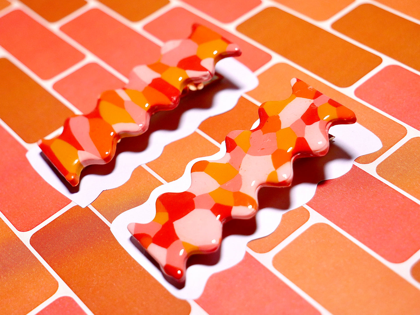 deux barrettes à cheveux faites à la main en argile polymèrede forme rétro et groovy de couleur rouge, ocre, terracotta et rose, avec une pince crocodile dorée