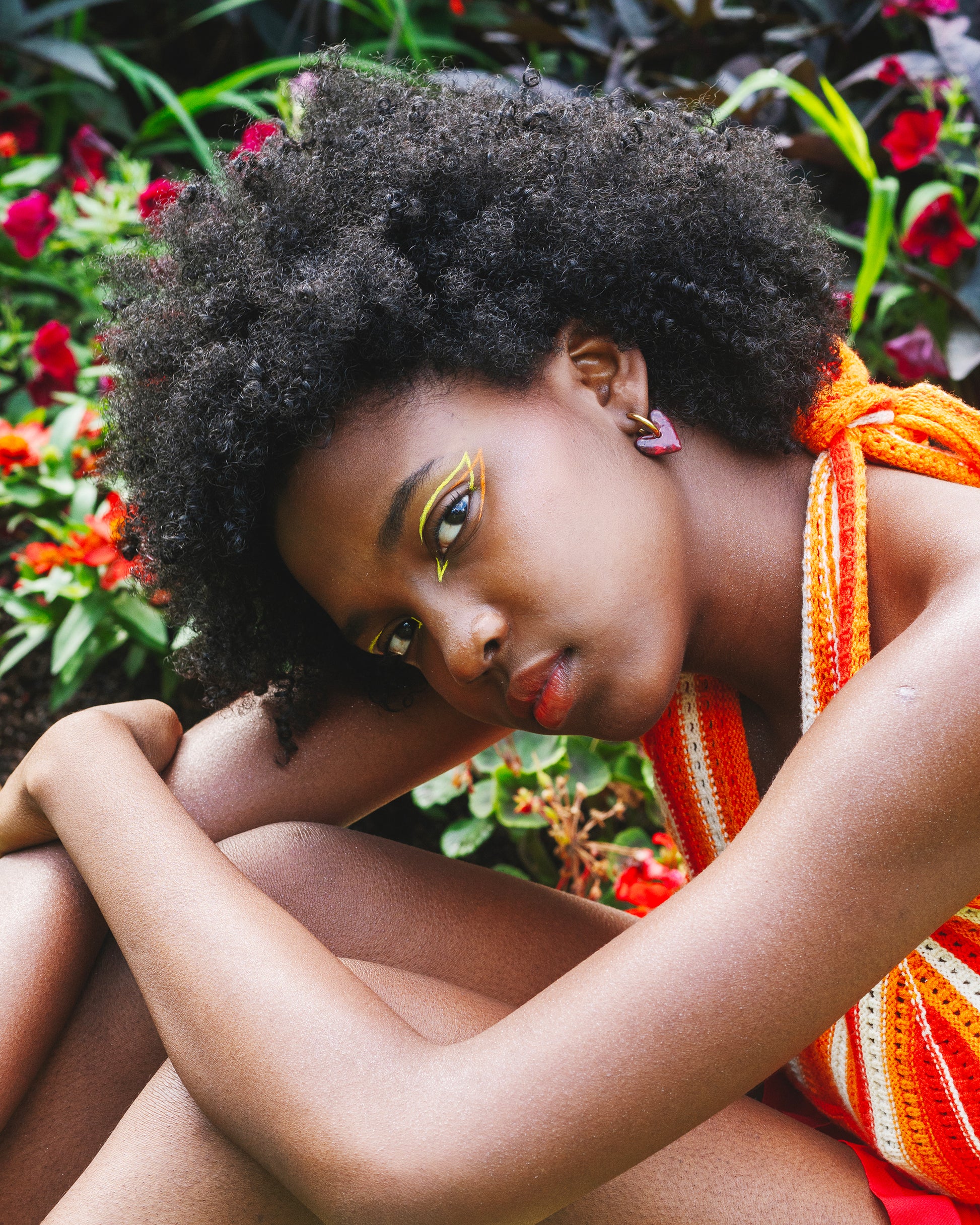 mannequin  à la peau noire  portant une boucle d'oreille fantaisie en forme de coeurs rouges, fait main en argile polymère, avec un anneau doré en acier inoxydable