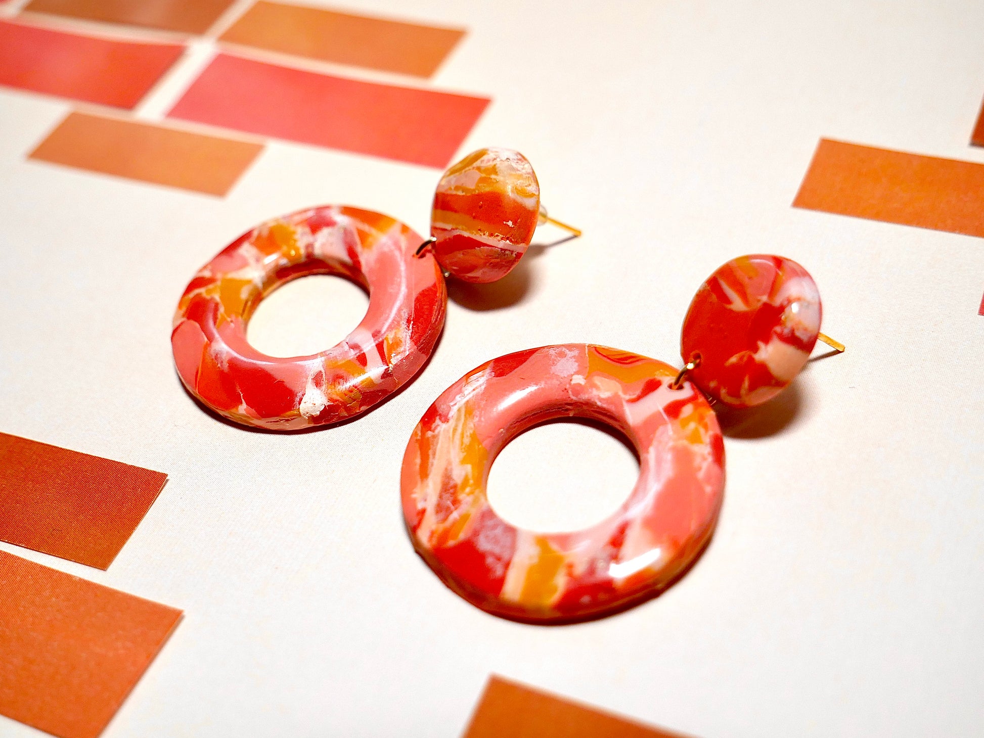 paire de boucles d'oreilles faite à la main composées de deux cercles marbrées oranges rose et rouge