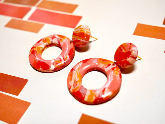 paire de boucles d'oreilles faite à la main composées de deux cercles marbrées oranges rose et rouge