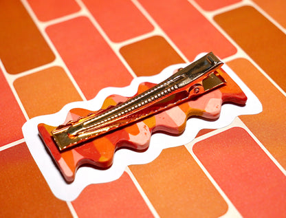 face arrière d'une barrette à cheveux faitesà la main en argile polymèrede forme rétro et groovy de couleur rouge, ocre, terracotta et rose, avec une pince crocodile dorée