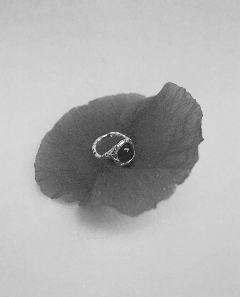 Bague en argent posée sur un pétale de coquelicot, en noir et blanc