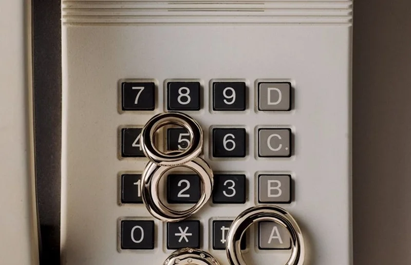 Bagues en argent posées sur les touches d'un interphone métallique